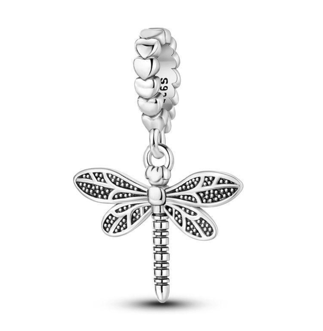 Silver dragonfly charm on a white background